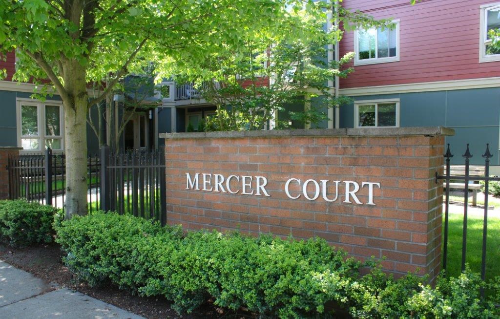 a brick sign for themer court in front of a house