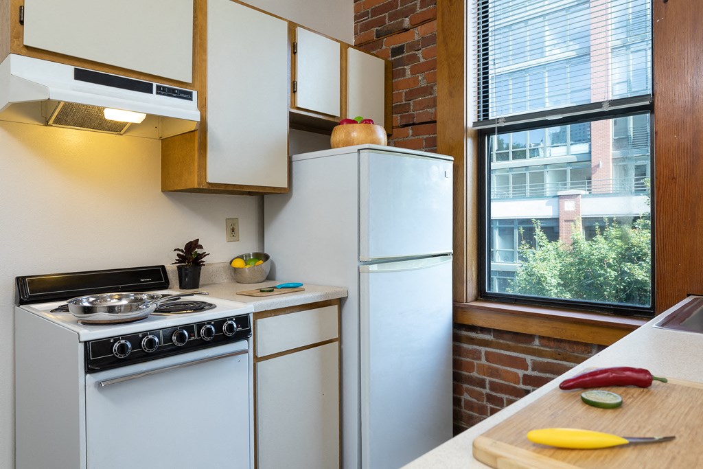 a small kitchen with white appliances and a window