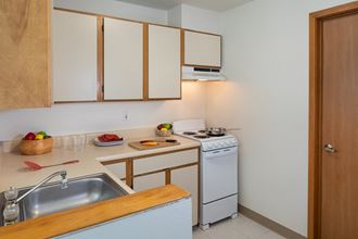 a kitchen with white appliances and wooden counter tops and a sink