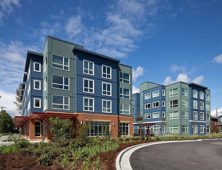 a row of new apartment buildings on the side of a road