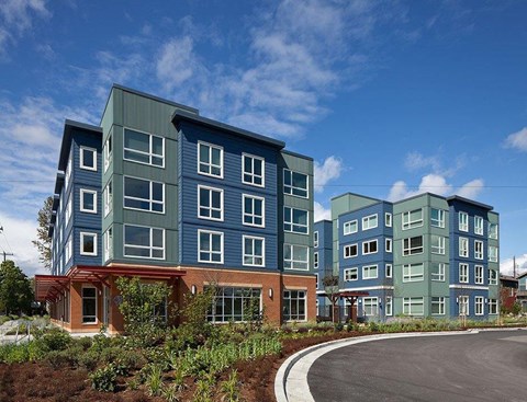 A modern building with a red brick base and blue panels on the upper floors.