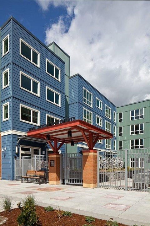 A modern building with a red canopy and a metal gate.