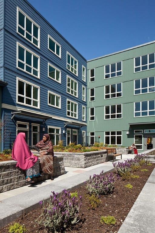 a woman walking in front of an apartment building