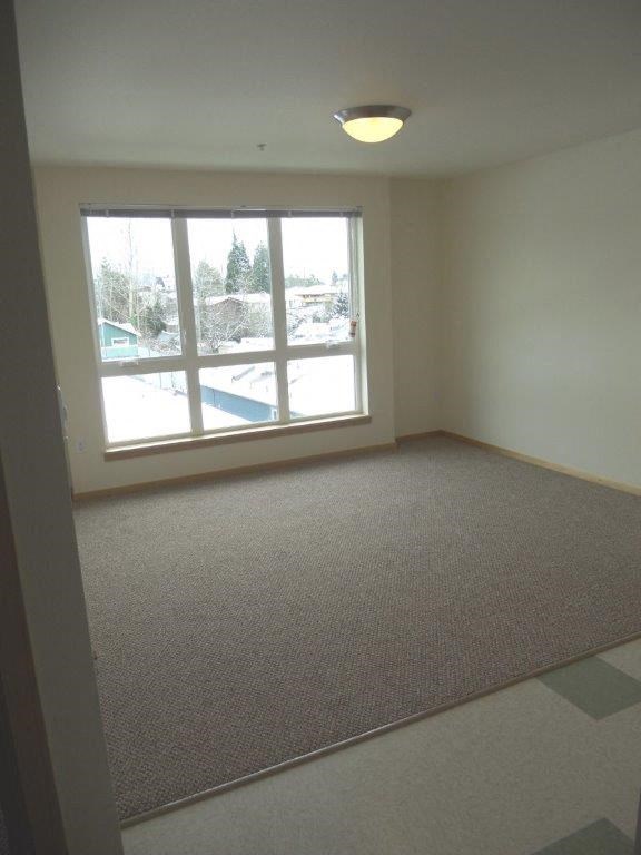 an empty living room with a large window