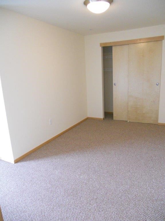 an empty room with a door to a closet