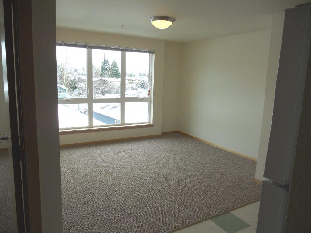 an empty living room with a large window
