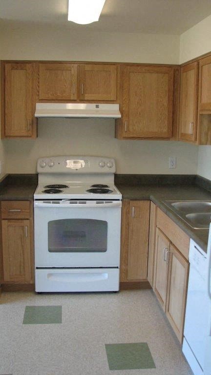 an empty kitchen with a stove and a sink