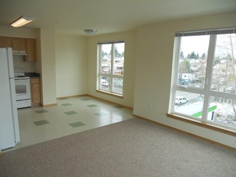 A kitchen with a refrigerator, oven, and sink.