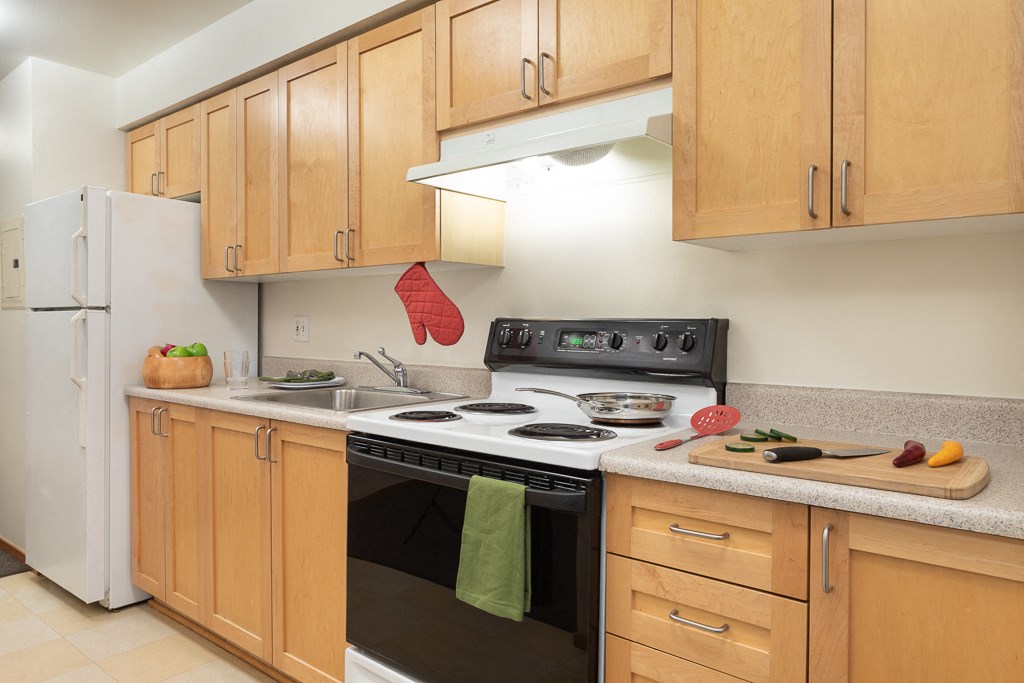 A kitchen with wooden cabinets and a black stove top.