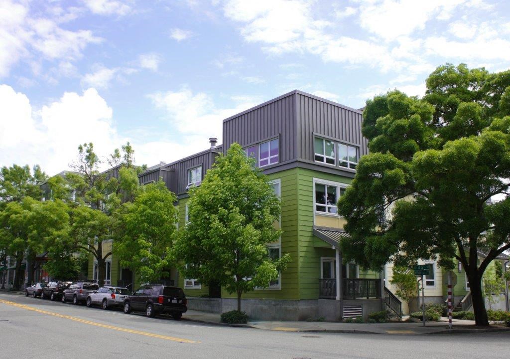 a green house with cars parked in front of it