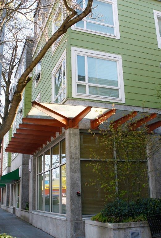 a green house with a tree in front of it