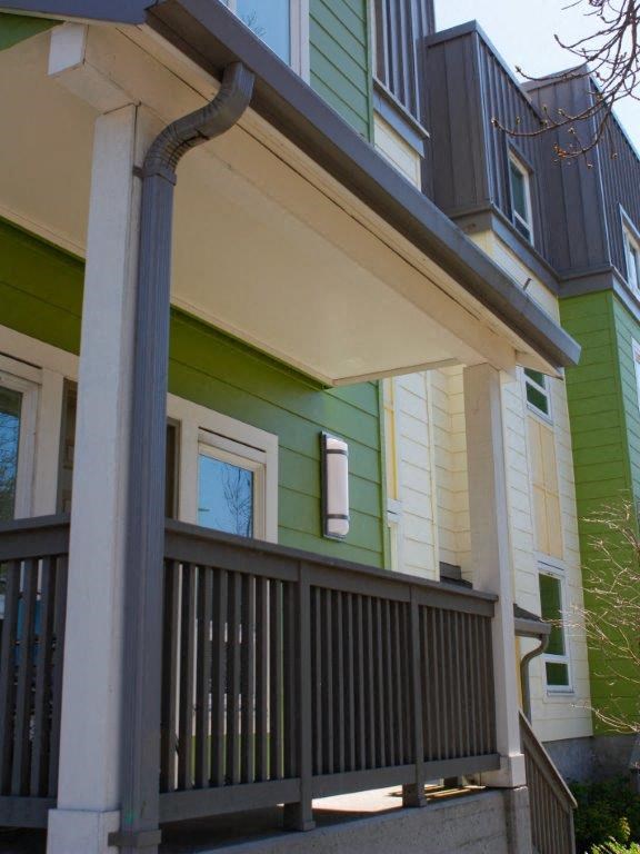 the front porch of a green and white house