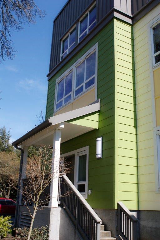 a green house with a porch and a window