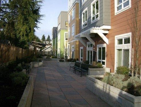 a sidewalk in front of a building with benches