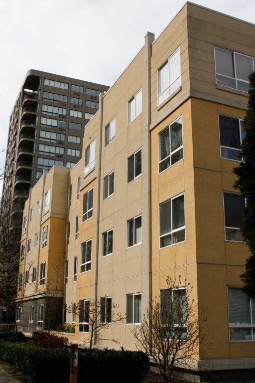 a brown building with a tall building in the background