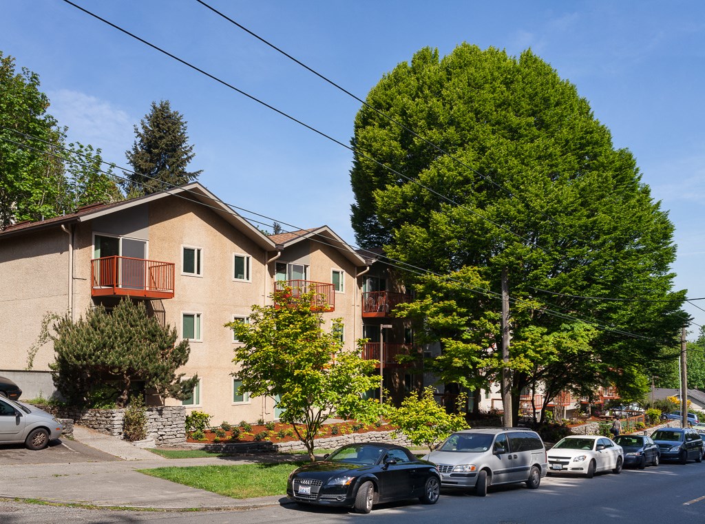 a house on a street with cars parked in front of it