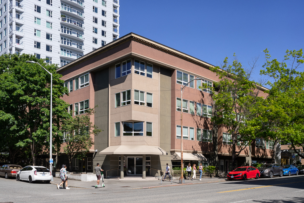 people walking in front of a building on a city street