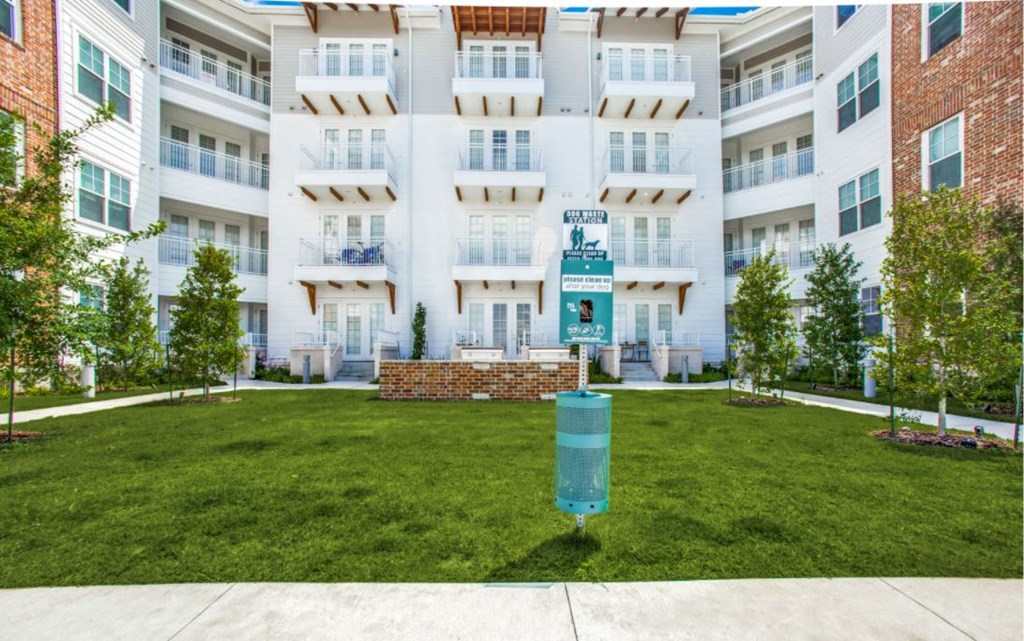 a large lawn in front of an apartment building with grass
