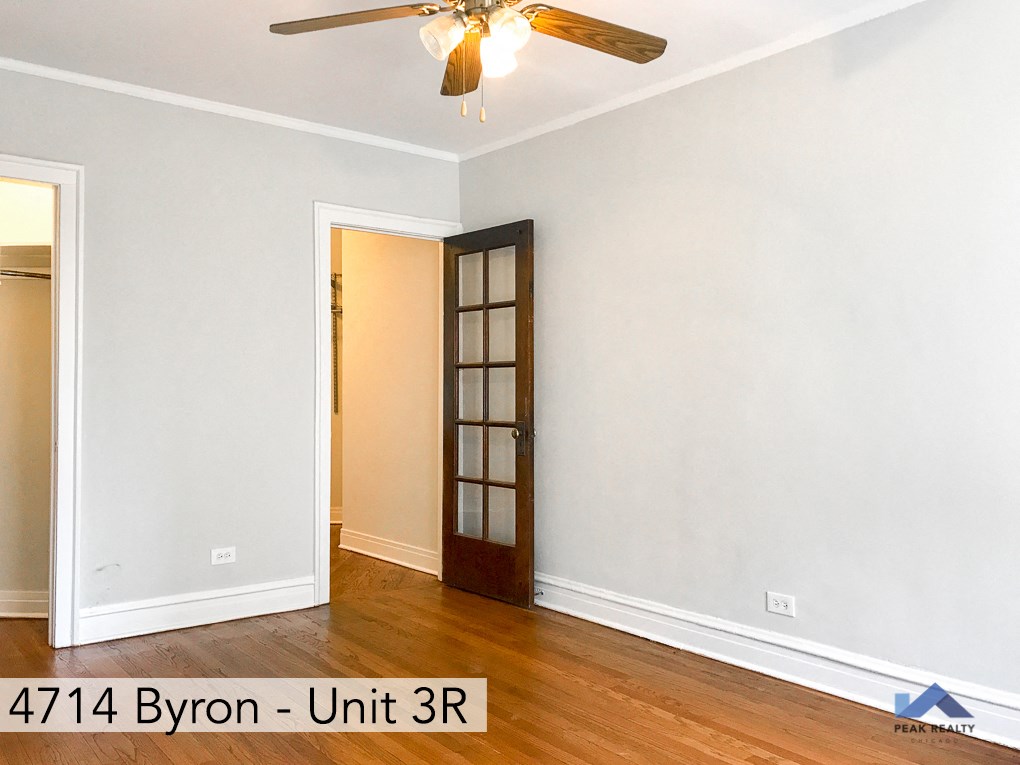 the interior of a room with a door and a ceiling fan