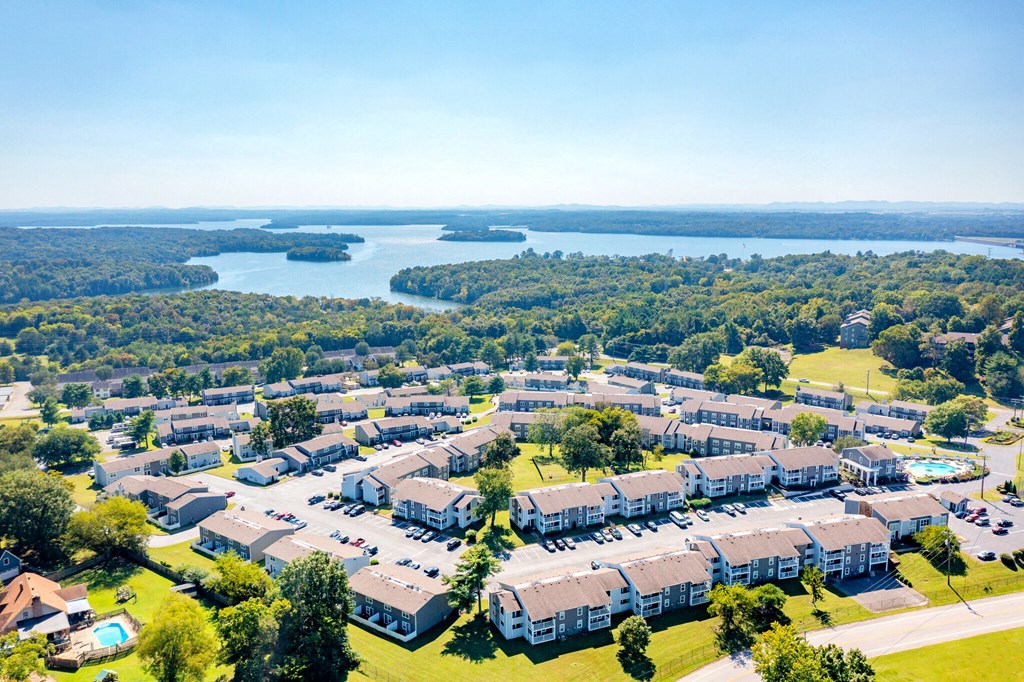 an aerial view of an apartment community with a lake in the background
