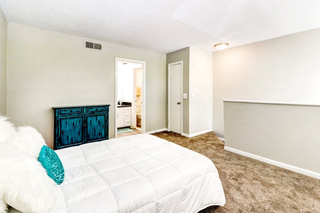 a bedroom with a white bed and a dresser