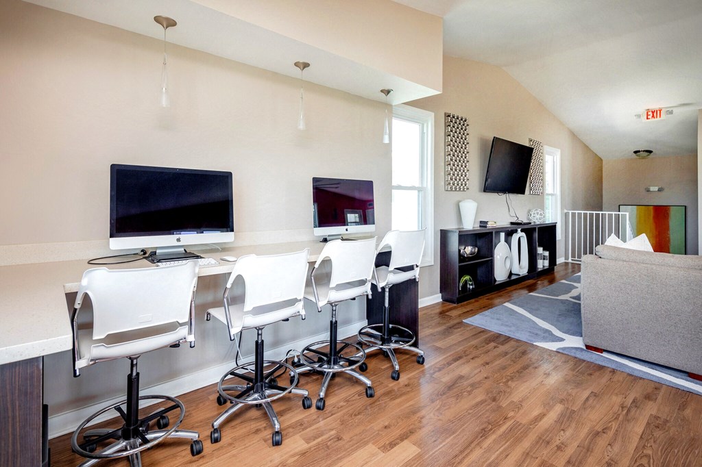 a conference room with a table and chairs and a tv on the wall