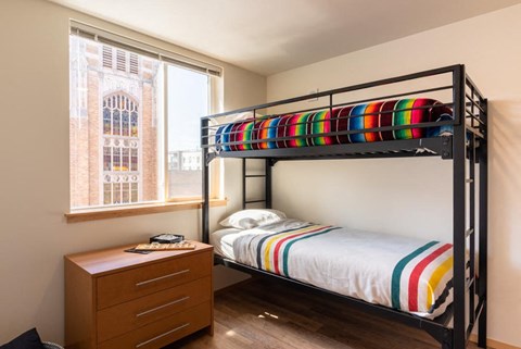 A bedroom with a bunk bed and a dresser.