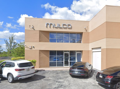 A building with the word "PULCO" on it has cars parked in front.