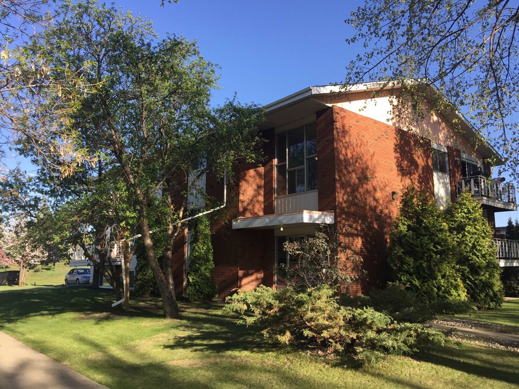 a red brick house with trees in front of it