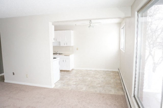 an empty living room and kitchen with a large window