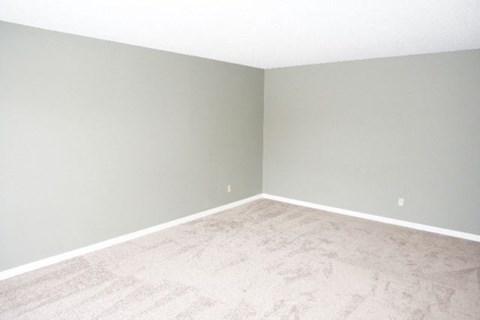 a empty room with a white floor and gray walls