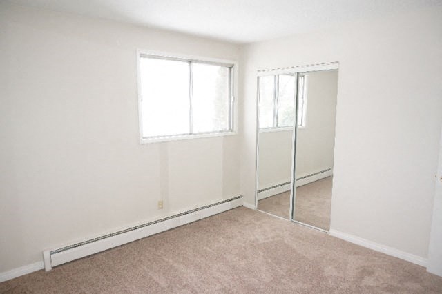 an empty room with a mirror and a window