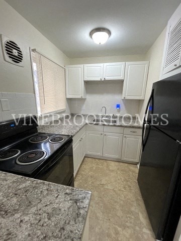a kitchen with black appliances and white cabinets