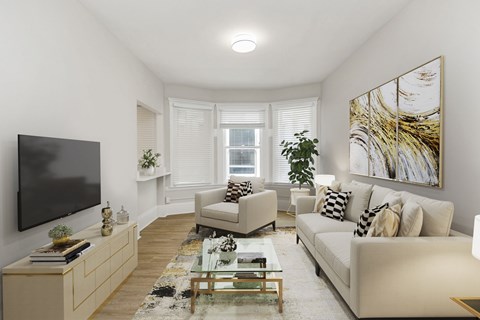 A living room with a white couch, a glass coffee table, and a large painting on the wall.