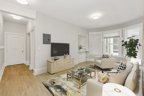 A living room with a white couch, a glass coffee table, and a flat screen TV.