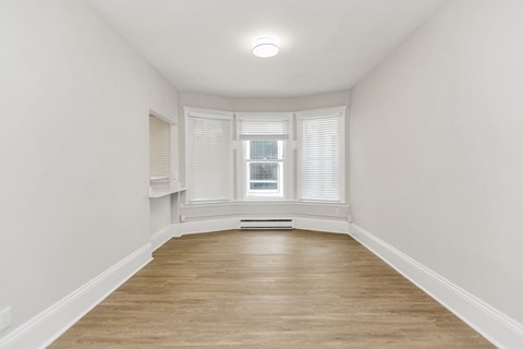 A room with a window and wooden flooring.