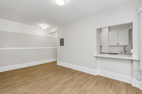 A room with wooden flooring and white walls.