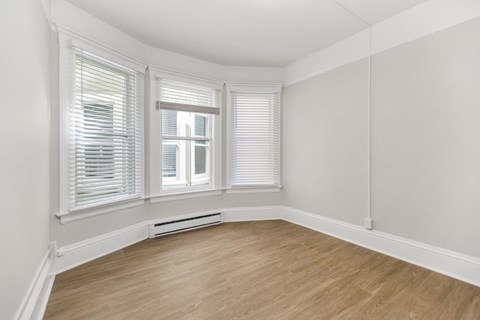 A room with a window and a radiator on the floor.