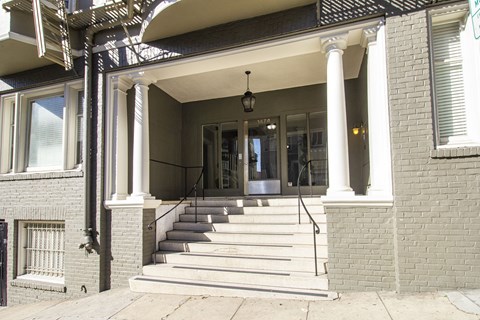 A house with a front porch and stairs leading to the entrance.