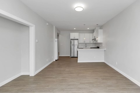 A kitchen with white cabinets and a wooden floor.