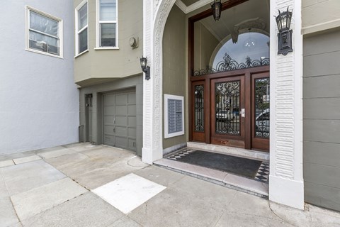 A house entrance with a glass door and a black mat.