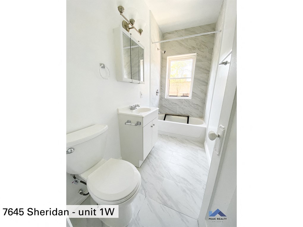 a white bathroom with a toilet and a tub and a sink