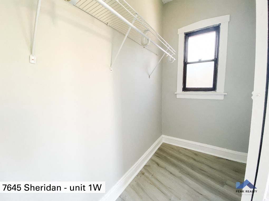 a room with white walls and a window and a hanger rack on the wall