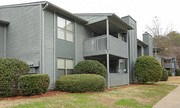 a gray house with a porch and some bushes