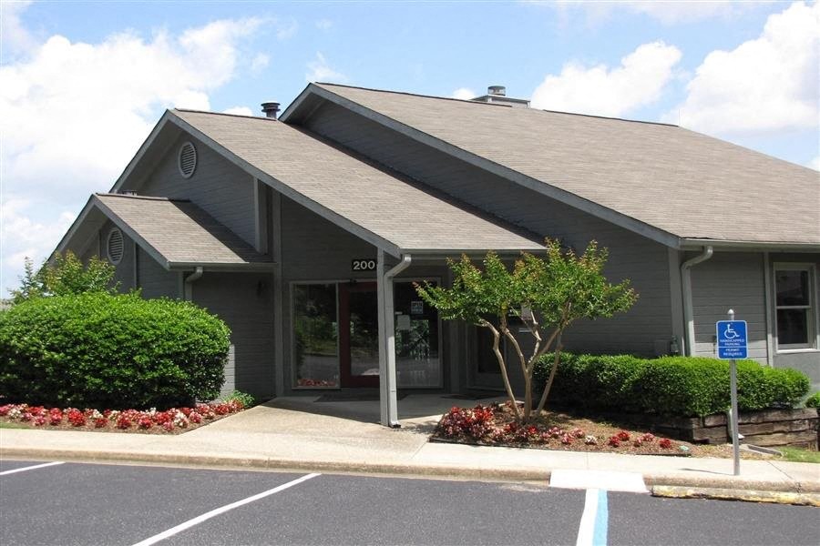 a grey building with a tree in front of it