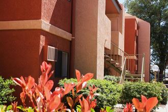 an orange building with red flowers in front of it