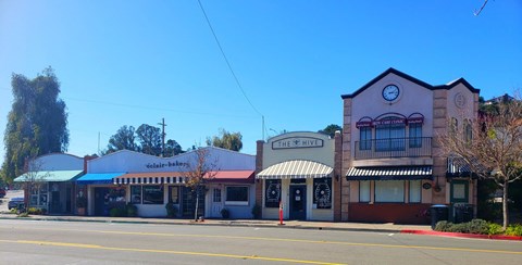 an old building with a clock on the side of a street