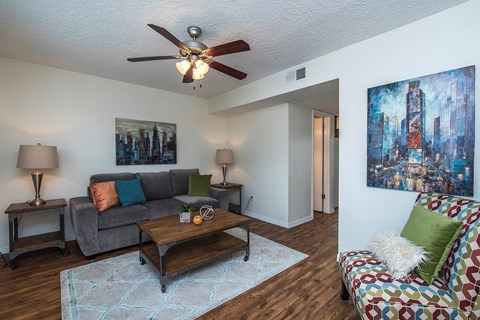 a living room with a couch and a ceiling fan