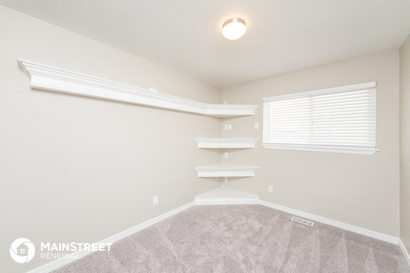the upstairs bedroom with white shelves and a window
