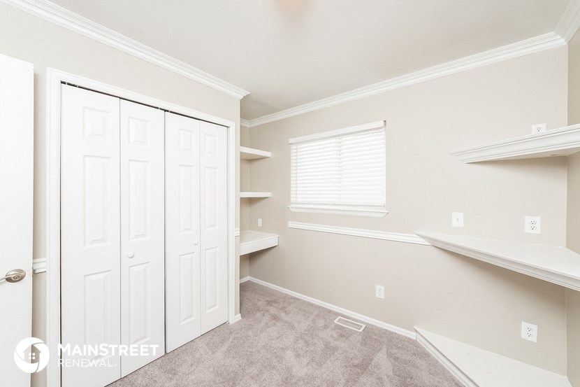 a bedroom with a closet and shelves and a window